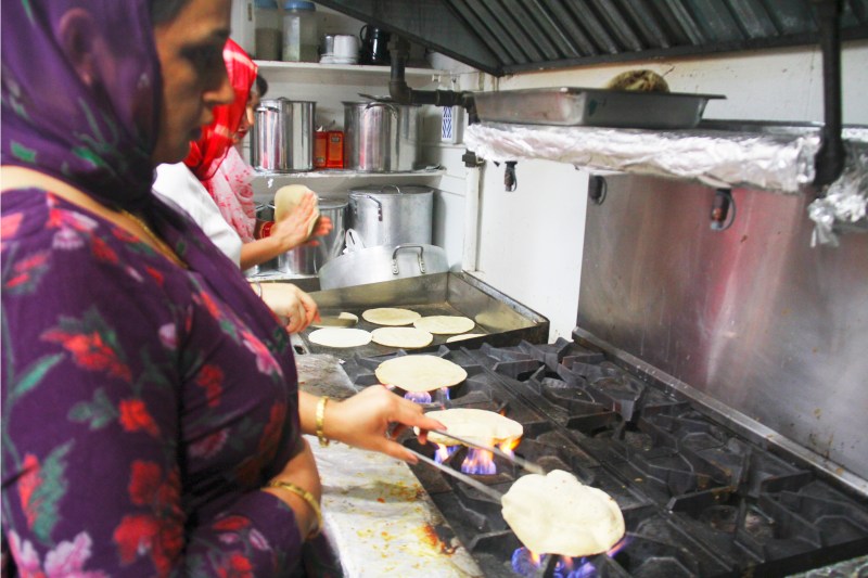 Woman roasting roti- Indian bread