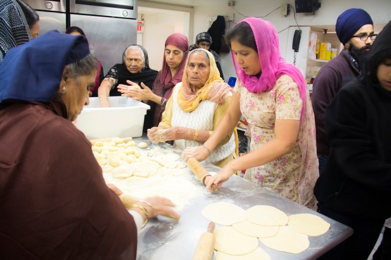 Woman rolling and kneading roti- Indian bread